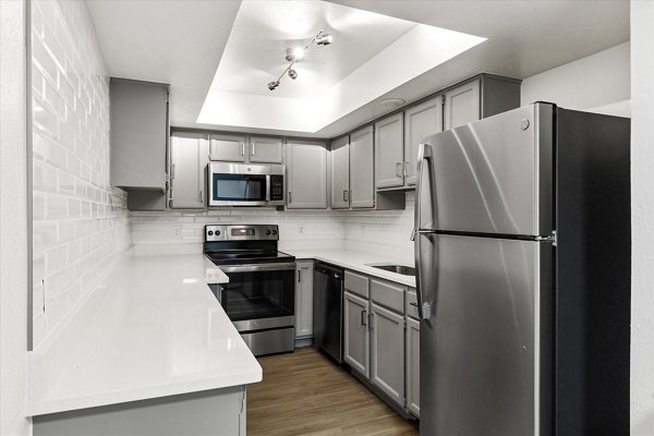 Modern kitchen with stainless steel appliances and quartz countertops in The Haven Apartments