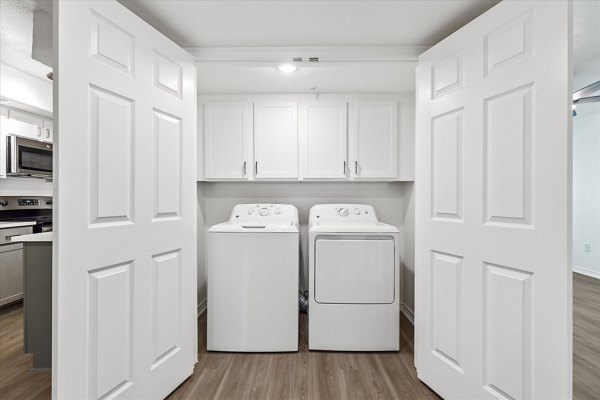 Laundry room with modern appliances at The Haven Apartments