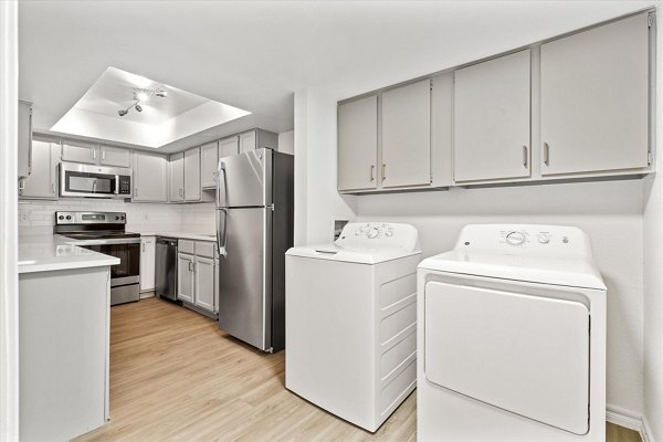 Laundry room with modern machines at The Haven Apartments, featuring energy-efficient washers and dryers in a convenient setup