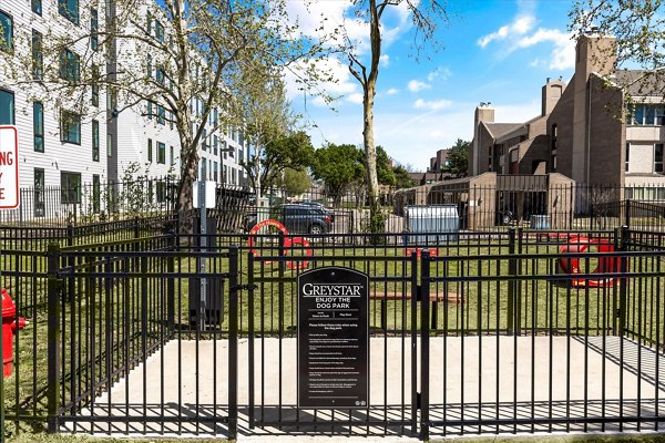 Well-designed dog park at The Haven Apartments featuring agility equipment and green space for resident pets