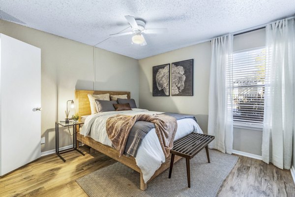 Bedroom with plush bedding and natural light at Woodland Trails Apartments