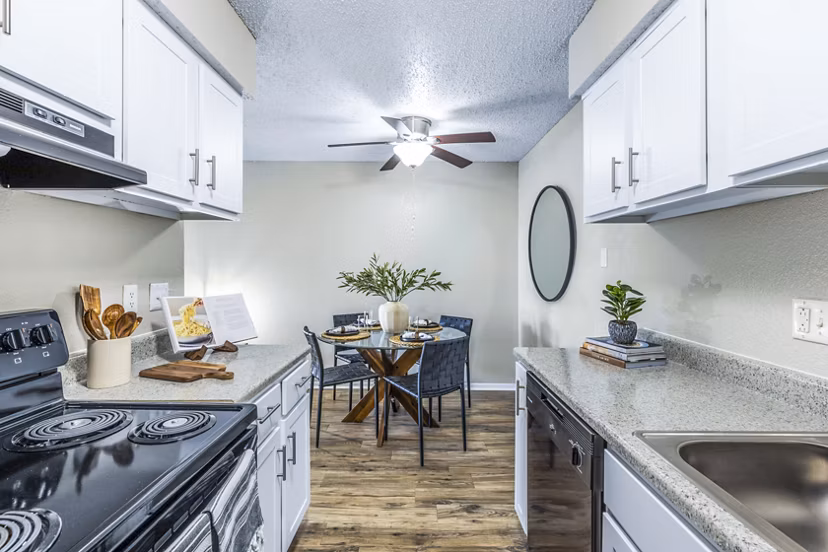 Kitchen and dining area with modern appliances and hardwood floors in Woodland Trails Apartments