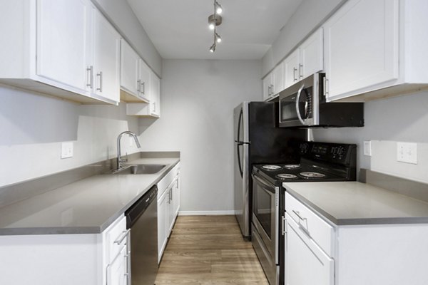 Modern kitchen with stainless steel appliances at Woodland Trails Apartments