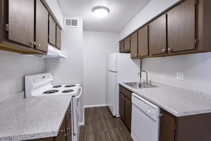 Modern kitchen featuring stainless steel appliances and granite countertops in Woodland Trails Apartments
