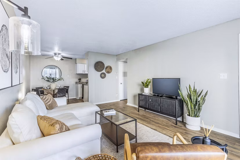 Living room featuring modern decor and large windows at Woodland Trails Apartments, luxury Greystar community