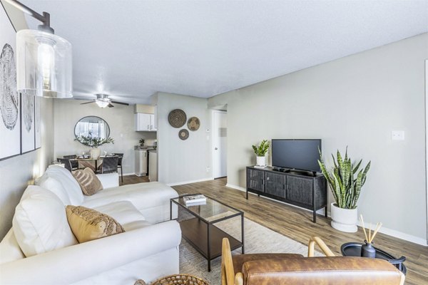 Living room featuring modern decor and large windows at Woodland Trails Apartments, luxury Greystar community