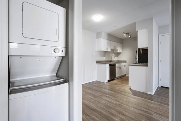 Laundry room featuring modern washers and dryers at Woodland Trails Apartments: Convenient amenities in luxury community