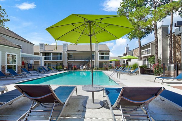Shimmering outdoor pool at Woodland Trails Apartments with lush landscaping