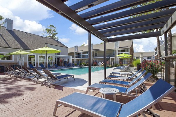 Relaxing outdoor pool at Woodland Trails Apartments amid lush surroundings