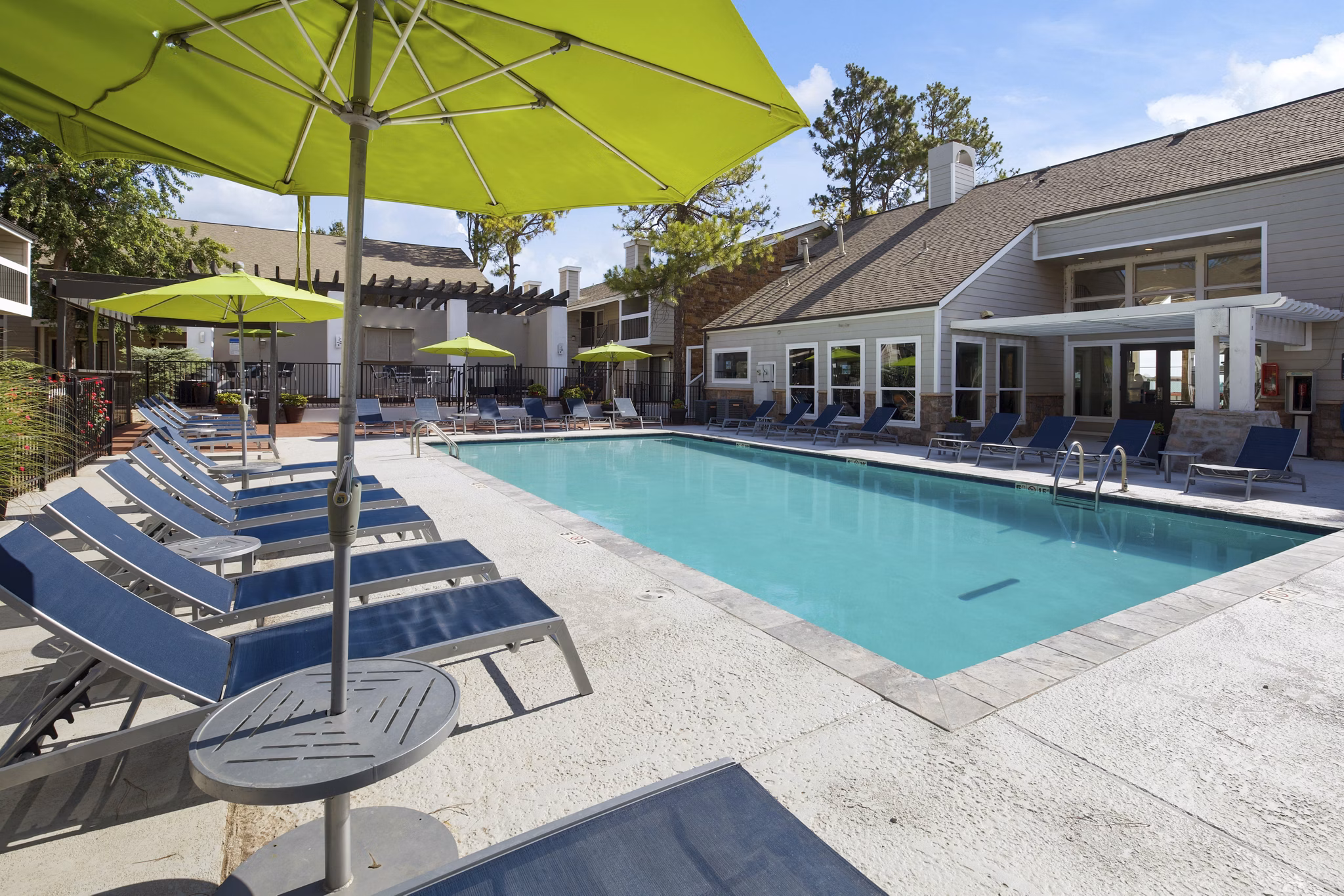 Luxury pool with loungers at Woodland Trails Apartments featuring resort-style amenities