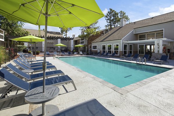 Luxury pool with loungers at Woodland Trails Apartments featuring resort-style amenities