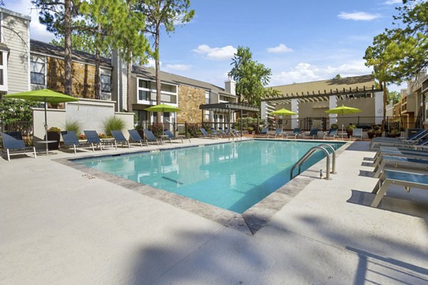 Sun-drenched poolside with loungers at Woodland Trails Apartments