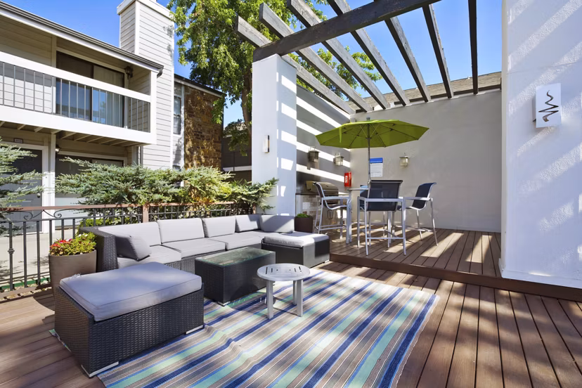 Outdoor grill area with modern seating at Woodland Trails Apartments, ideal for social gatherings and alfresco dining