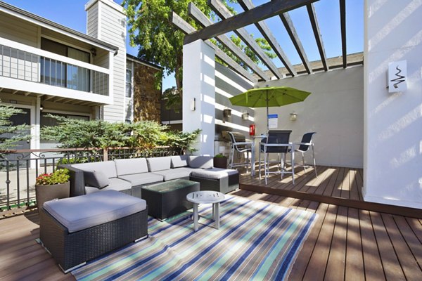 Outdoor grill area with modern seating at Woodland Trails Apartments, ideal for social gatherings and alfresco dining
