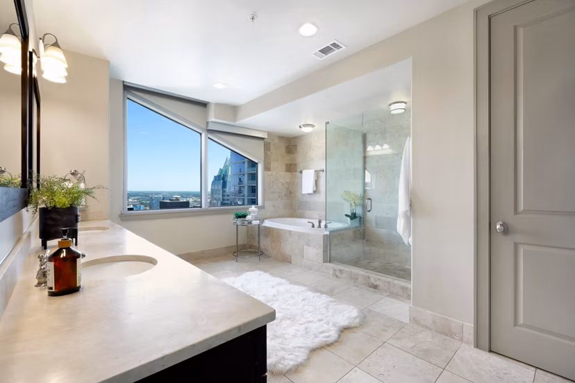Sleek bathroom featuring a modern vanity and large mirror at Ashton Austin Apartments