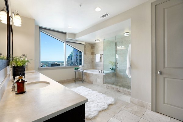 Sleek bathroom featuring a modern vanity and large mirror at Ashton Austin Apartments