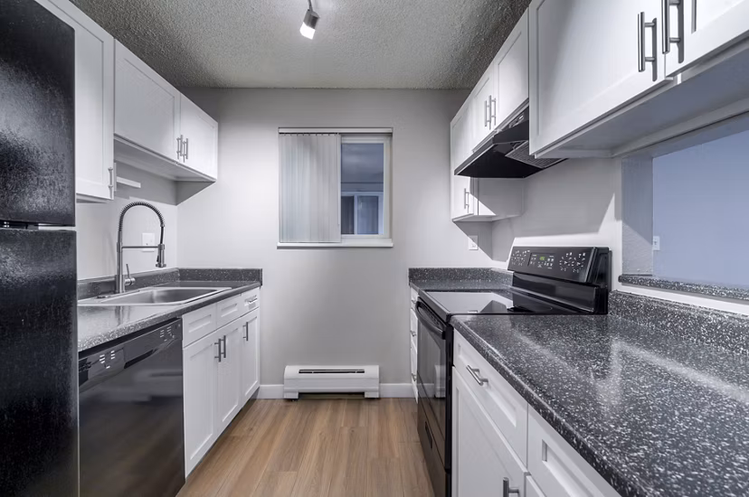 Modern kitchen featuring sleek countertops and stainless steel appliances in Westbury Apartments
