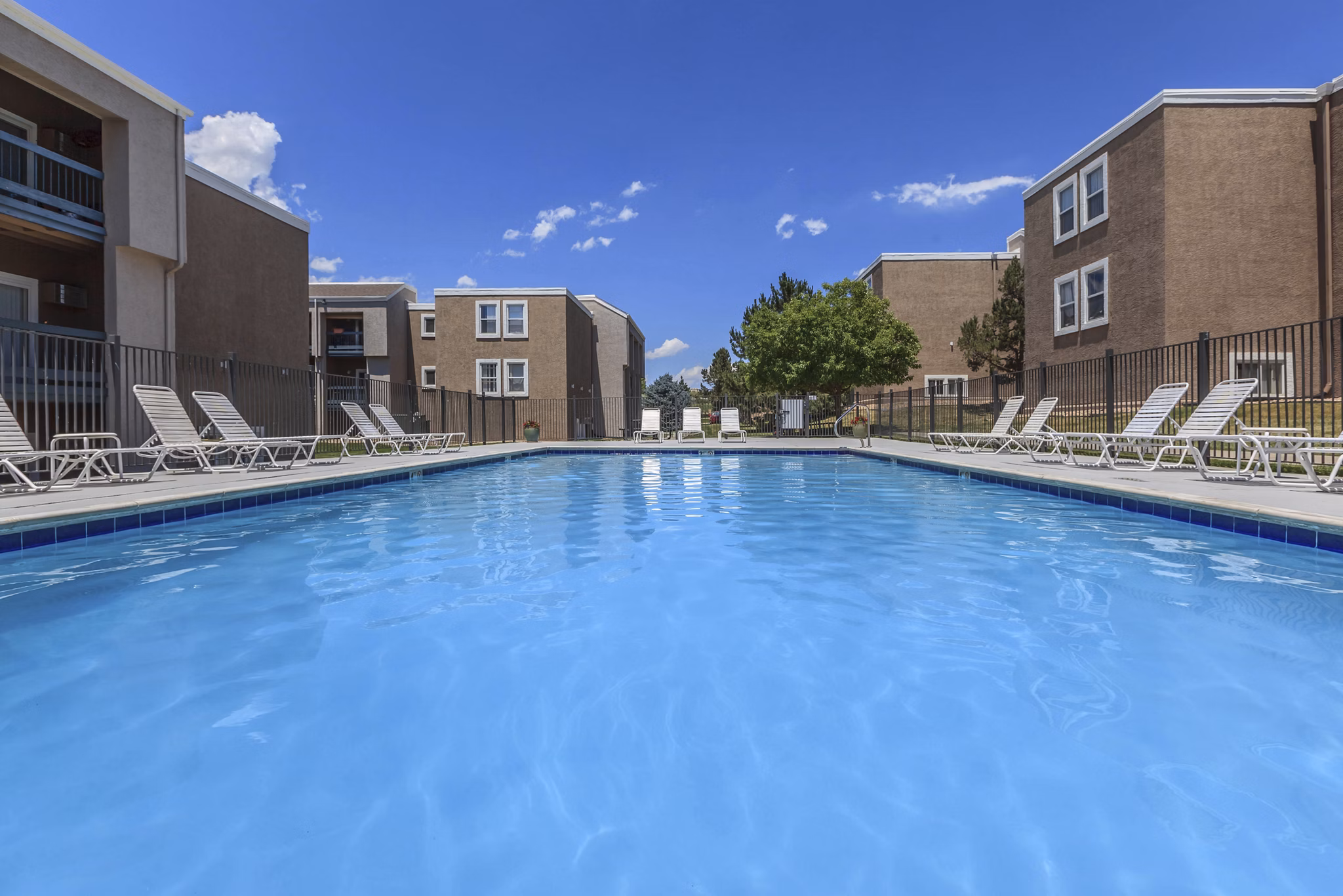 Outdoor pool surrounded by lush landscaping at Westbury Apartments luxury community, perfect for relaxation and recreation