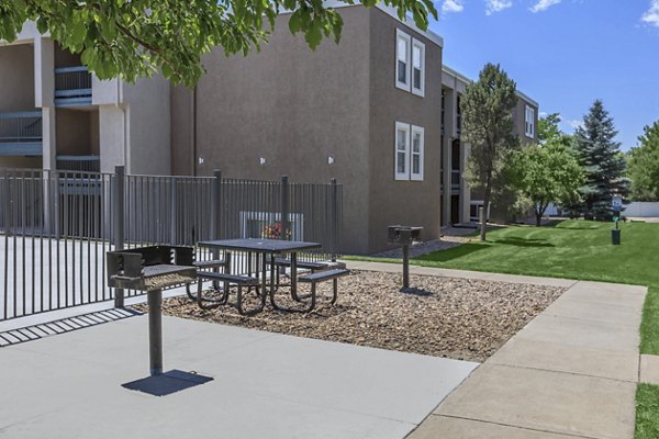 Outdoor grill area at Westbury Apartments with seating and lush landscaping for resident gatherings