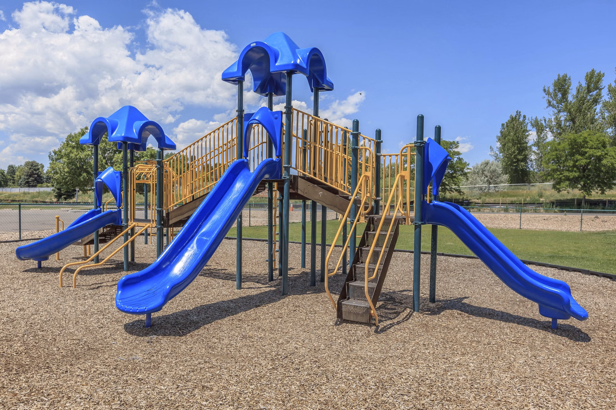 Colorful playground with slides and swings at Westbury Apartments, offering family-friendly amenities for luxury living