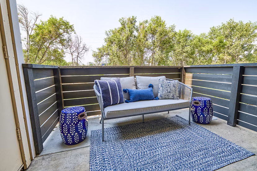 Outdoor patio with seating area and greenery at Greenwood Point Apartments: luxury living spaces by Greystar