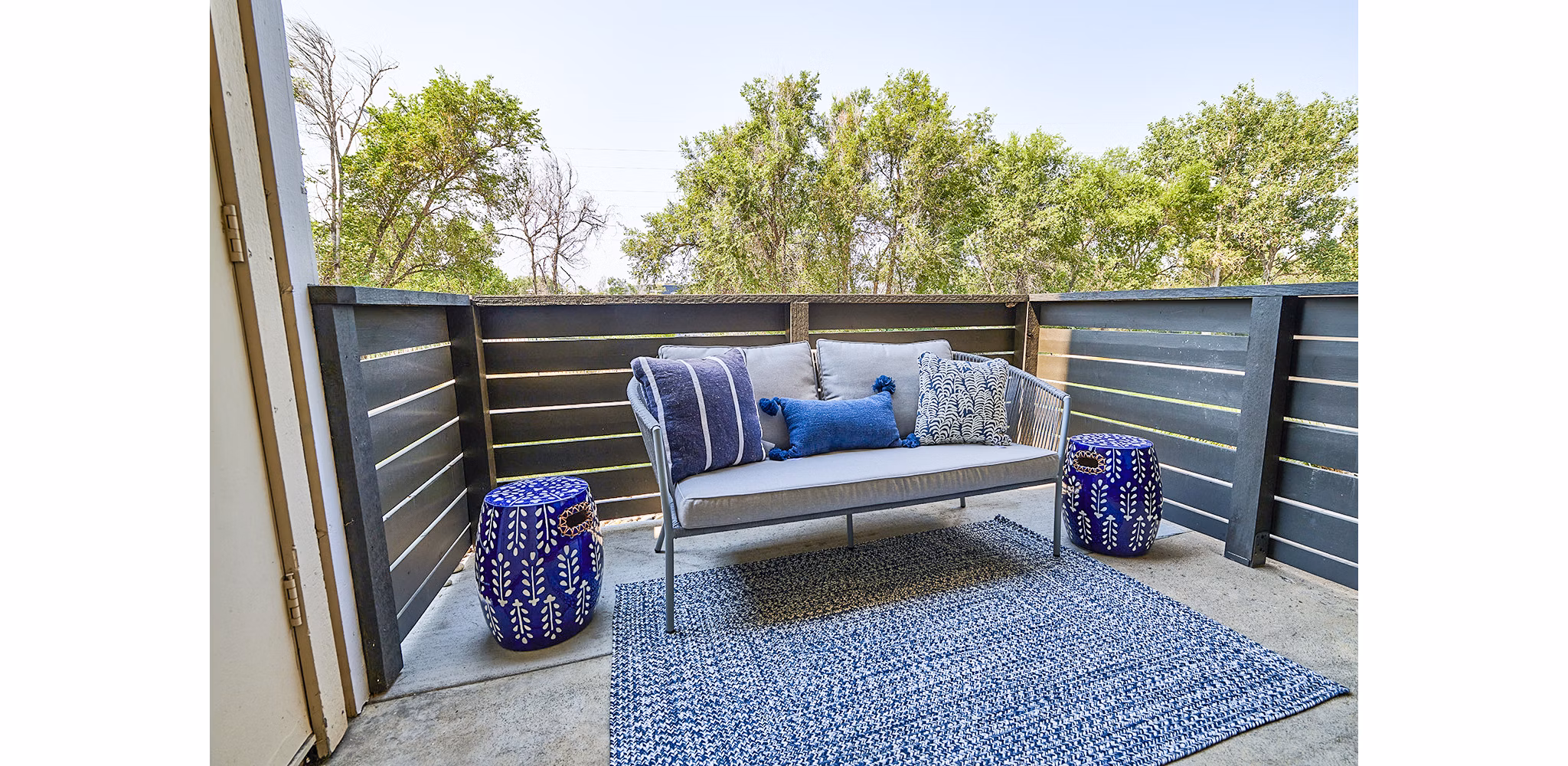 Outdoor patio with seating area and greenery at Greenwood Point Apartments: luxury living spaces by Greystar