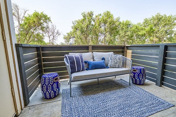 Outdoor patio with seating area and greenery at Greenwood Point Apartments: luxury living spaces by Greystar