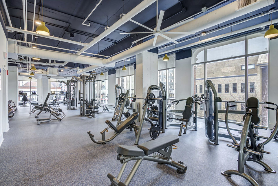 Fitness center with modern equipment at Landmark Apartments featuring cardio machines and weight stations