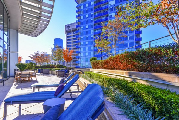 Modern patio area with comfortable seating at The Olivian Apartments, featuring elegant landscaping in a vibrant urban setting