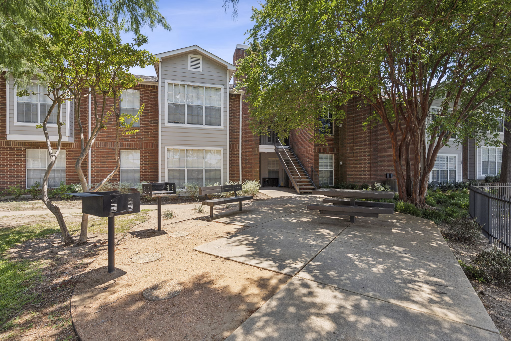 Outdoor grill area with modern seating at Townlake of Coppell Apartments, perfect for hosting gatherings and enjoying alfresco dining experiences