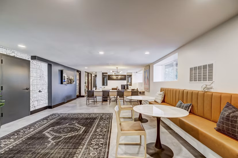 Modern office reception area with desk and wall-mounted TV at Cambridge Place luxury apartments