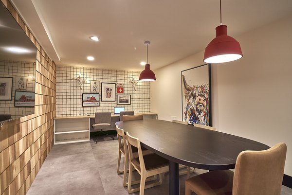 Modern office space featuring a long table, chairs, and stylish pendant lights in luxury apartments