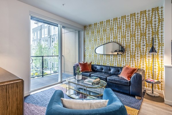 Spacious living room with modern decor at Jackson Apartments, featuring cozy seating and city views