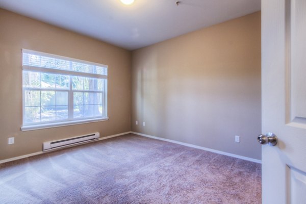 Cozy bedroom with modern decor at Bradley Park Apartments featuring plush bedding and ample natural light