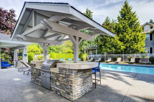 Outdoor pool and grill area at Bradley Park Apartments, ideal for relaxation and social gatherings in a luxury setting