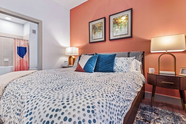 Cozy bedroom with modern decor and ample natural light at Rhythm Apartments