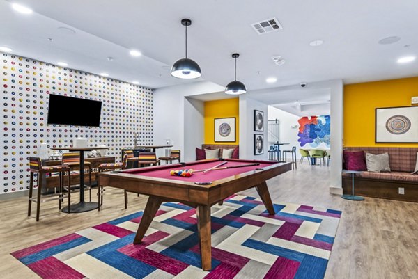 Clubhouse game room with arcade games and pool table in Rhythm Apartments for luxury living