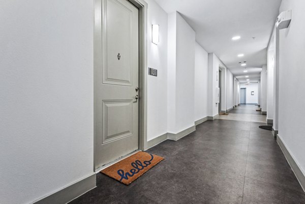Hallway leading to residences at Rhythm Apartments featuring modern lighting and decor, part of Greystar luxury apartment communities
