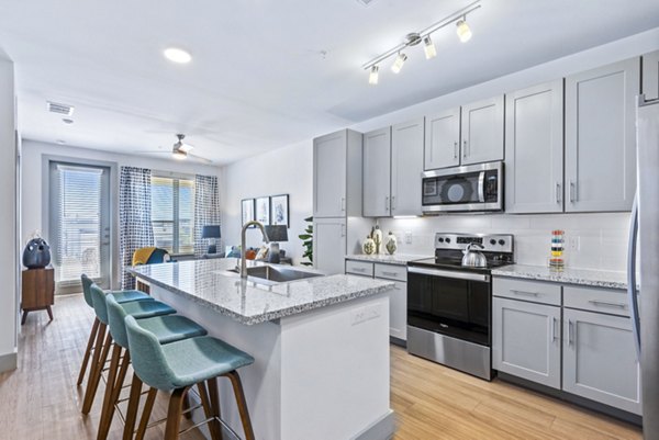 Modern kitchen featuring sleek countertops and stainless steel appliances in Rhythm Apartments