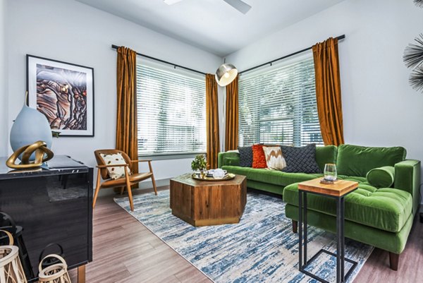 Modern living room with sleek furniture and large windows at Rhythm Apartments, a Greystar luxury property