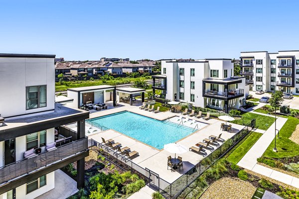Poolside relaxation at Rhythm Apartments: Luxury swimming pool surrounded by lush landscaping for comfortable living