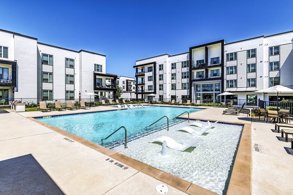 Rooftop pool with lounge chairs at Rhythm Apartments