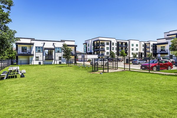 Spacious dog park with agility equipment at Rhythm Apartments, providing a pet-friendly environment for residents