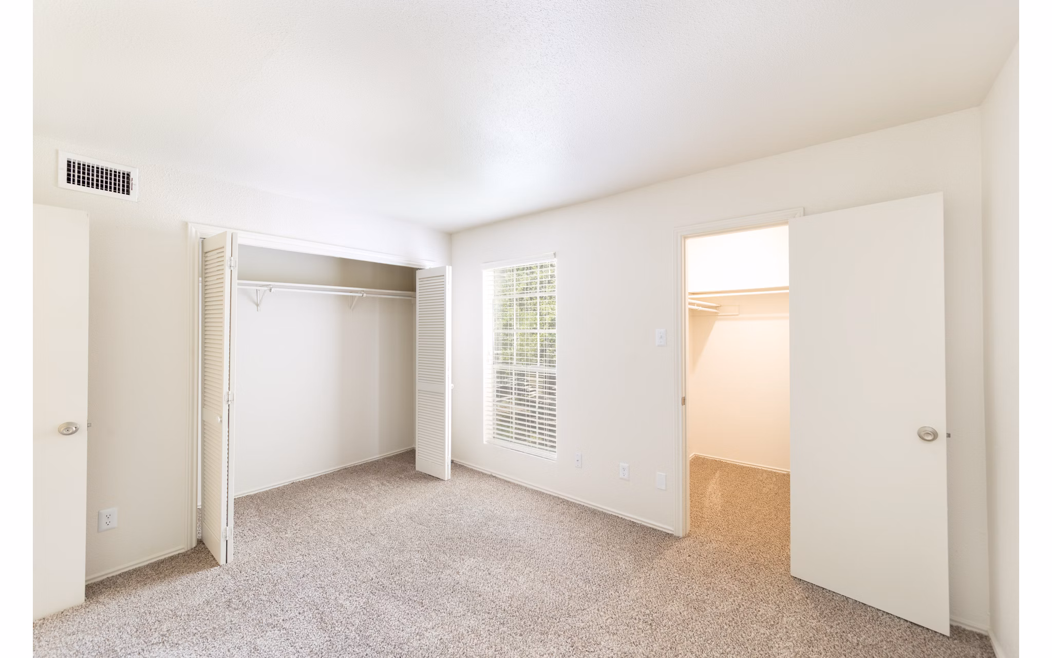 Cozy bedroom with modern furnishings at Copper Ridge Apartments featuring a plush bed and natural light through large windows, ideal for luxury living