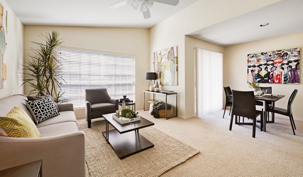 Living room with stylish furniture and large windows in Copper Ridge Apartments