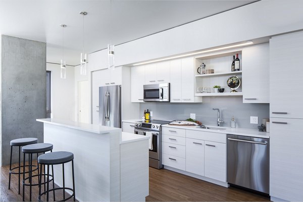 Modern kitchen featuring stainless steel appliances and sleek countertops in West Edge Apartments