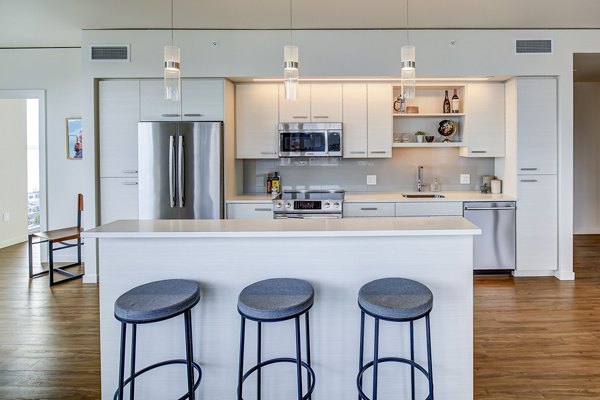 Modern kitchen featuring sleek countertops and stainless appliances in West Edge Apartments, luxury living space in the heart of the city