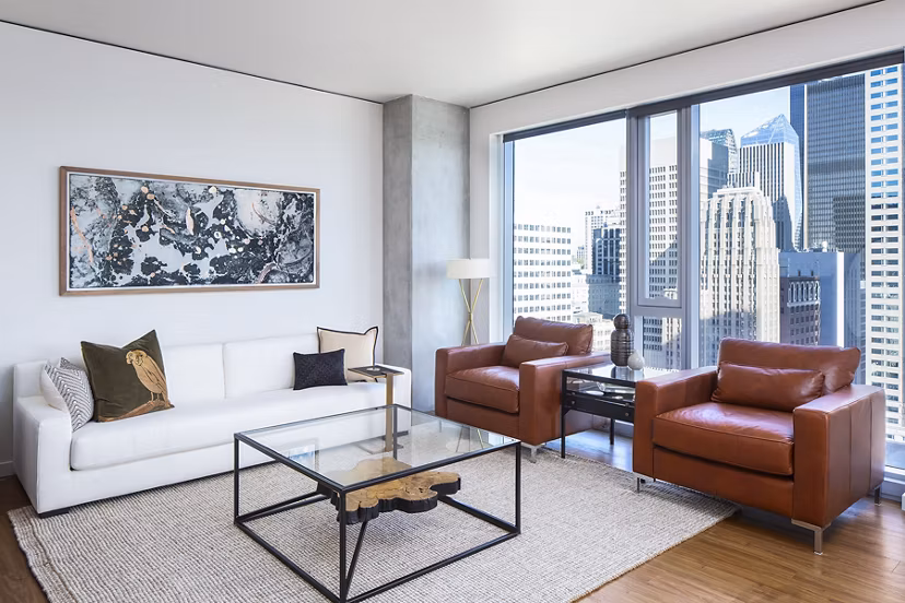 Modern living room with sleek furniture and expansive windows at West Edge Apartments