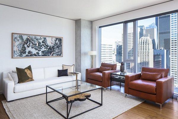 Modern living room with sleek furniture and expansive windows at West Edge Apartments