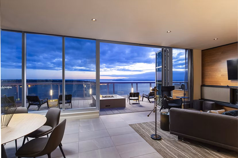 Modern living room with sleek furnishings at West Edge Apartments, featuring floor-to-ceiling windows and sophisticated decor